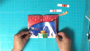Christmas cardの２枚の紙の下の部分をそろえ、中央の折り目を合わせて貼ります